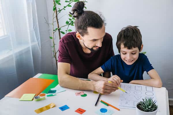 male parent doing schoolwork with child 1