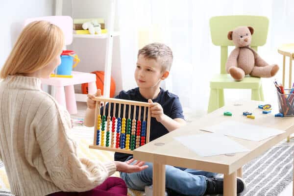 white child with toy showing blonde female therapist 1