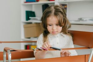 A child lining up pencils, which may be a sign the child needs ABA therapy.