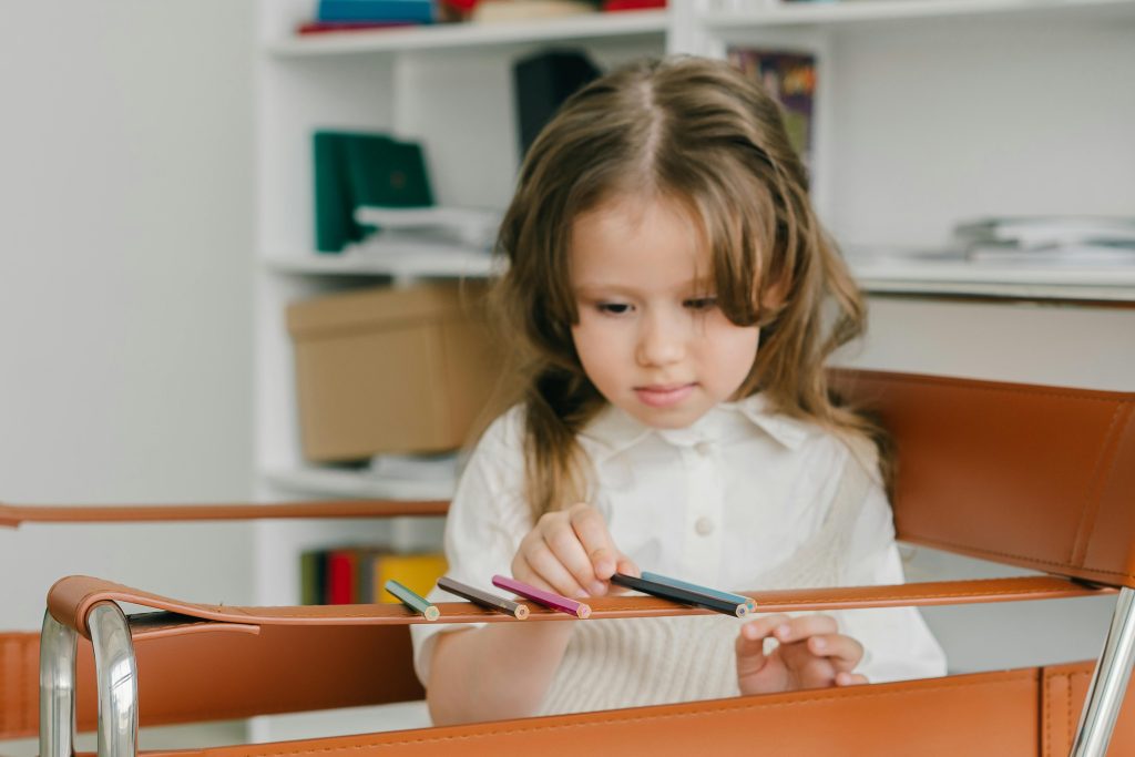 A child lining up pencils, which may be a sign the child needs ABA therapy.