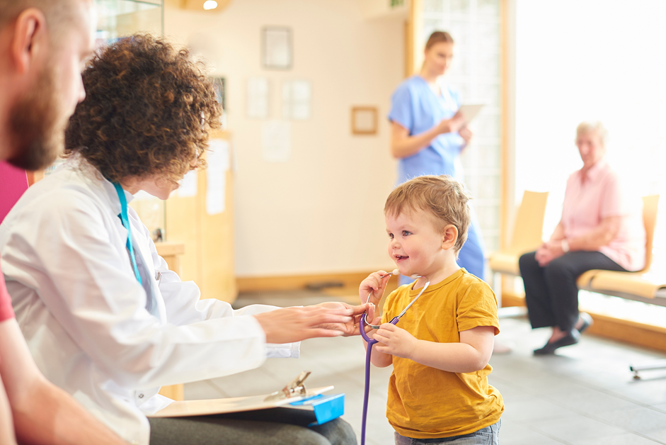 Child playing with a doctor, as might happen in an early autism screening.