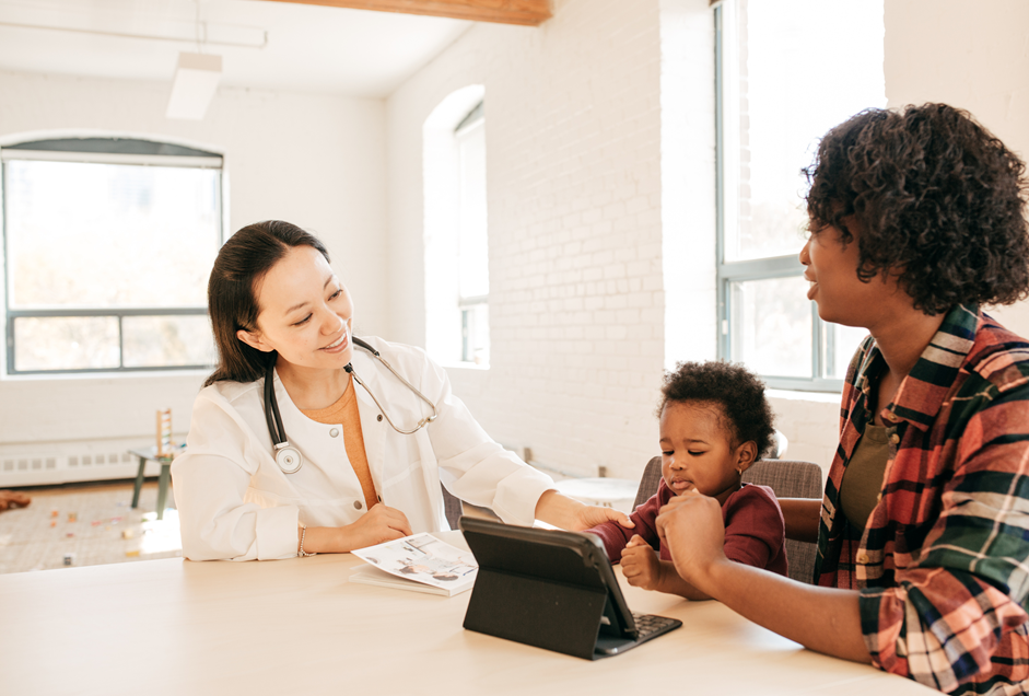 A pediatrician with a mother and child during an autism screening