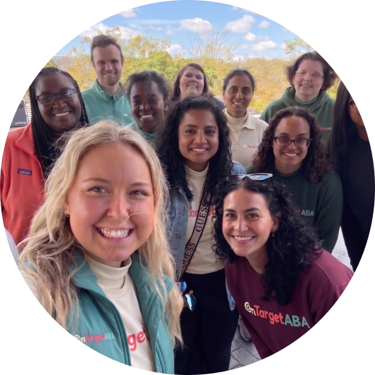 Group photo of a diverse team of smiling professionals outdoors.