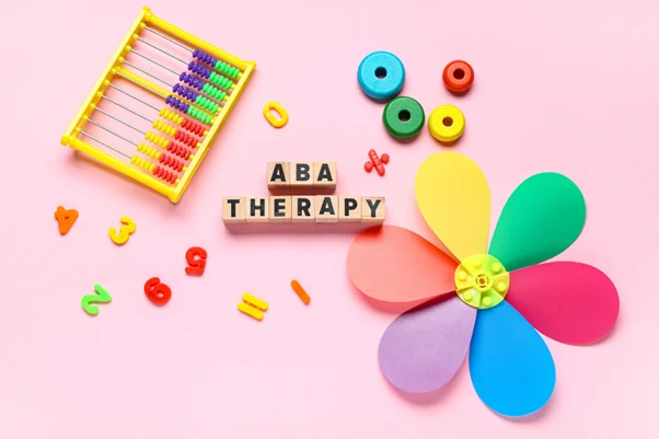 ABA Therapy Wooden blocks spelling out ABA Therapy, surrounded by toys. Preference Assessment is vital in ABA.