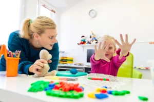 An ABA therapist presenting various toys to a child as part of a preference assessment. 